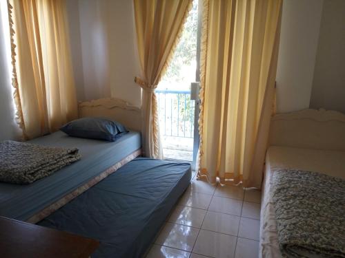 two twin beds in a room with a window at Admiral Villa in Carita