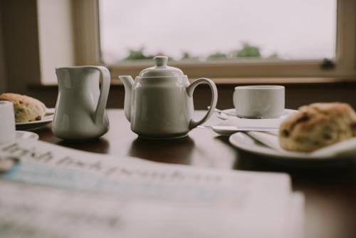 a table with a tea pot and cups on it at Royal Valentia Hotel in Valentia Island