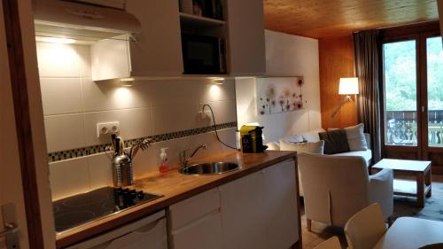 a kitchen with a sink and a living room at Between lake en ski resort in Thollon