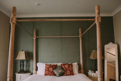 a bedroom with a canopy bed with pillows on it at Royal Valentia Hotel in Valentia Island