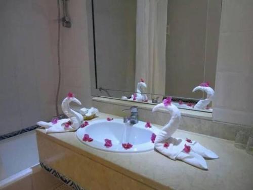 a bathroom with a sink with swans on it at Palmyra Golden Beach - Families and Couples in Monastir