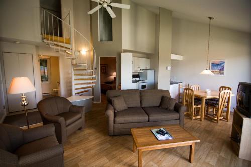 a living room filled with furniture and a fire place at Chalets Condos sur le Fjord in LʼAnse-Saint-Jean