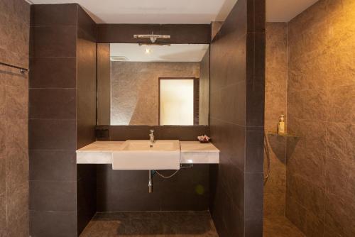 La salle de bains est pourvue d'un lavabo et d'un miroir. dans l'établissement Samui Mermaid Beachfront, à Bangrak Beach