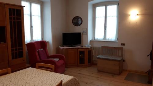 sala de estar con TV y 2 sillas en Casa da Aldo en Castelfondo