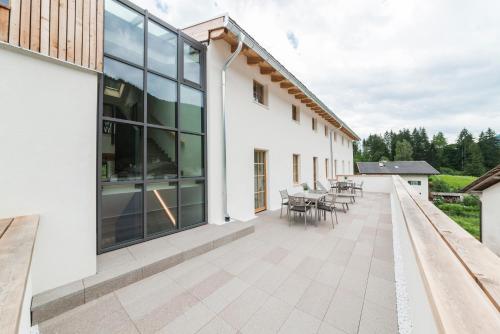 a patio with tables and chairs on a building at Zum Hirschen Boutique Hotel Val di Non in Unsere Liebe Frau im Walde