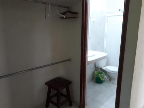 a bathroom with a toilet and a sink and a stool at Casa Azul in Valladolid