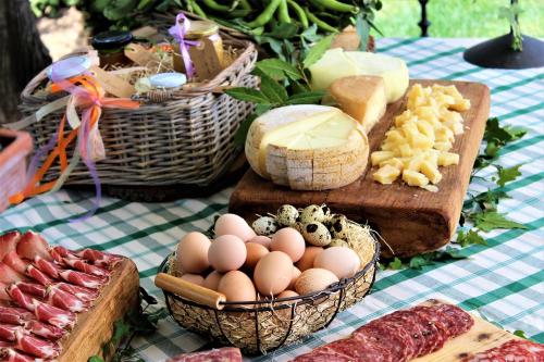Una mesa con cestas de huevos, queso y carnes. en La Cantina Relais - Fattoria Il Cipresso, en Arezzo