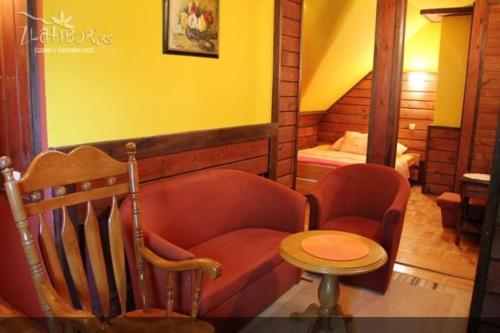 a room with a couch and a table and a bed at Guest House Alpska Vila in Zlatibor