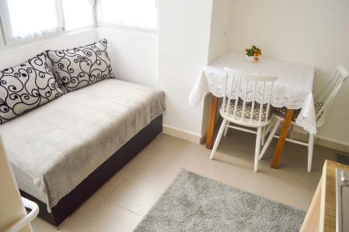 a small room with a table and a bed and a table and chair at Apartment Riverside Gem in Novi Sad