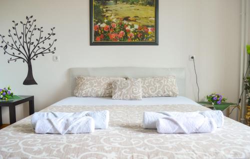 a bedroom with a bed with a painting on the wall at Apartment Riverside Gem in Novi Sad