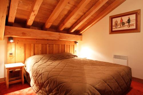 une chambre avec un grand lit dans une pièce dans l'établissement Vacanceole - Résidence Goléon -Val Ecrins, à Les Deux Alpes
