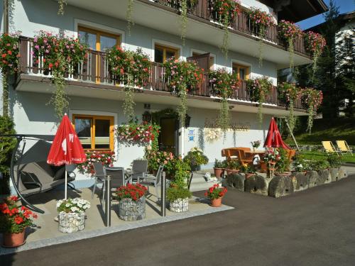 a building with flowers and umbrellas in front of it at Pension Isabella in Bad Kleinkirchheim