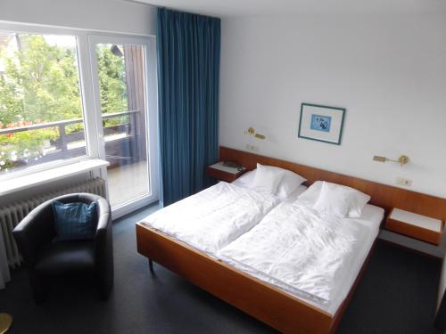 a bedroom with a bed and a chair and a window at Bremer Schlüssel in Braunlage