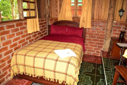 a bedroom with a bed in a brick wall at Hosteria Kindi Wasi in Puyo