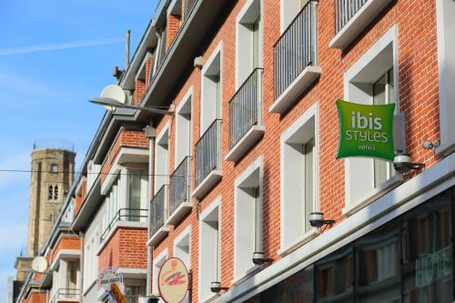 a sign on the side of a building with a lot of windows at ibis Styles Calais Centre in Calais