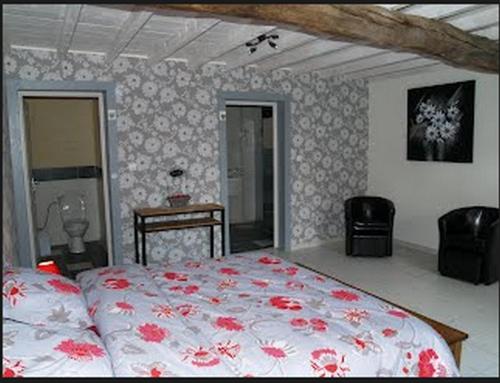 a bedroom with a bed with red flowers on it at Maison Sarrau in Varès