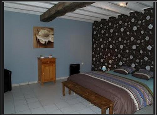 a bedroom with a large bed and a wall at Maison Sarrau in Varès