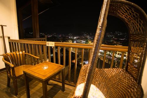 a chair and a table on a balcony with a view at Wang Jiang Reclusive Boutique Inn in Fenghuang