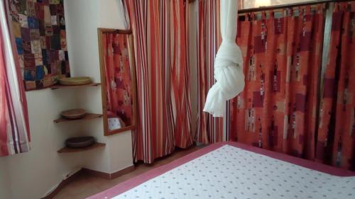 a room with red curtains and a bed with a white mattress at Très belle Villa dans Résidence Safari Saly Senegal in Saly Portudal