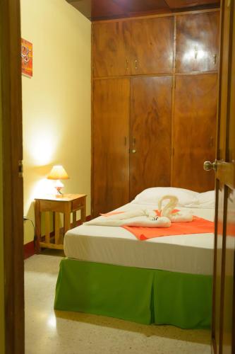 a bedroom with a bed with a large wooden headboard at Hostal Fachente in León