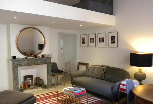 a living room with a couch and a mirror at La Terrasse du Marché aux Fleurs in Montpellier