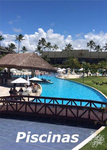 a bridge over a swimming pool in a resort at Flat Beach Class Resort Muro Alto in Porto De Galinhas