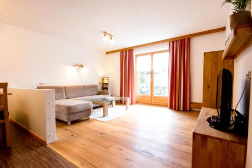 a living room with a couch and a tv at Haus Vlcek in Nauders