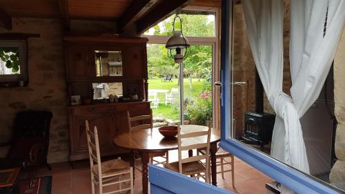 a dining room with a table and a window at La Ferme de Kerhors in Tréméoc