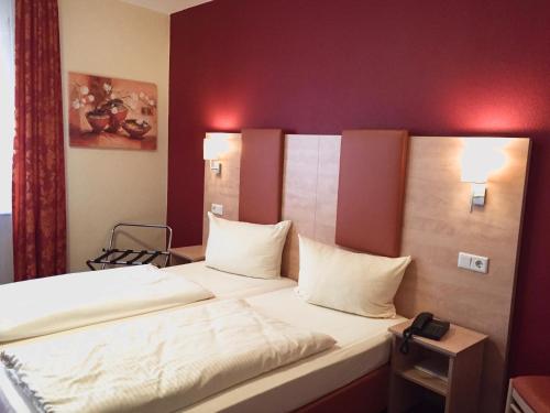 a bed with white sheets and pillows in a room at Rheinhotel Rüdesheim - Wellness in Rüdesheim am Rhein