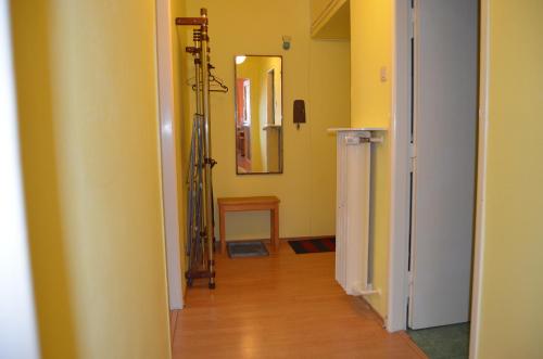 a hallway with a room with yellow walls and wooden floors at Apartments Letna in Prague