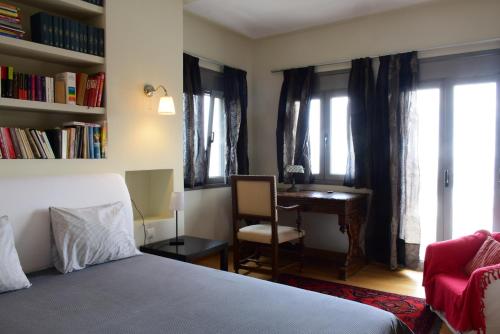 a bedroom with a bed and a desk and a chair at La Belle Helene in Kymi