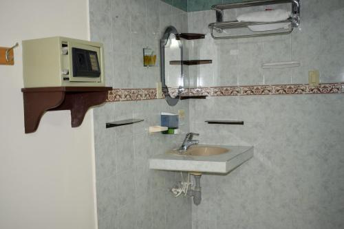 a bathroom with a sink and a microwave on the wall at Cafe Inn Casa Hotel in Montenegro