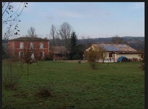 a green field with two houses and a building at Maison Sarrau in Varès