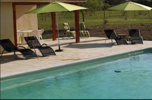 a group of chairs and umbrellas next to a swimming pool at Maison Sarrau in Varès