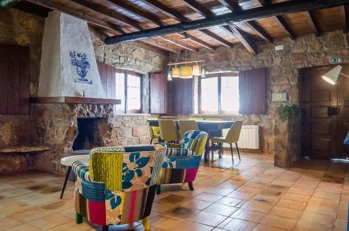 a room with chairs and a table and a fireplace at Casa Da Padeira - Turismo Rural in Alcobaça