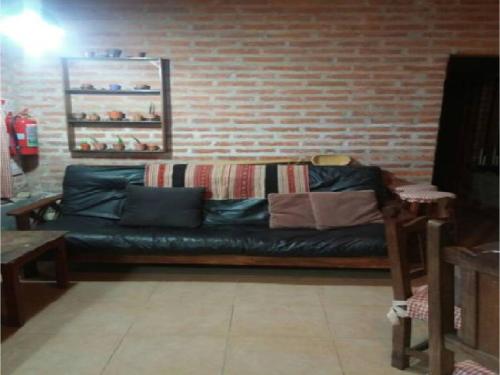 a couch in a room with a brick wall at Cabaña San Pablo in San Salvador de Jujuy