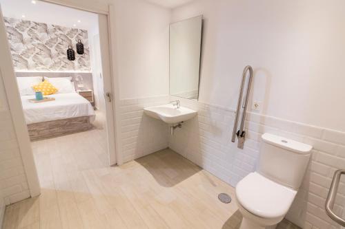 a bathroom with a toilet and a sink and a bed at BeSalamanca in Salamanca
