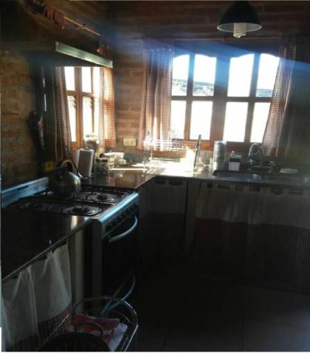 a kitchen with a stove and a sink at Cabaña San Pablo in San Salvador de Jujuy