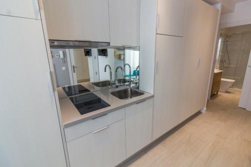 a kitchen with white cabinets and a sink at BeSalamanca in Salamanca