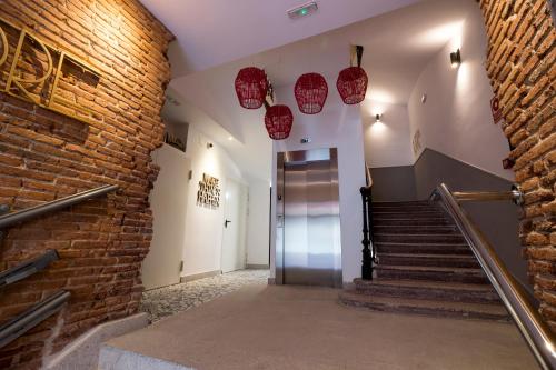 a hallway with stairs and a brick wall at BeSalamanca in Salamanca