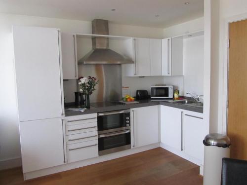 a kitchen with white cabinets and a microwave at Bridge Street Apartments in Inverness