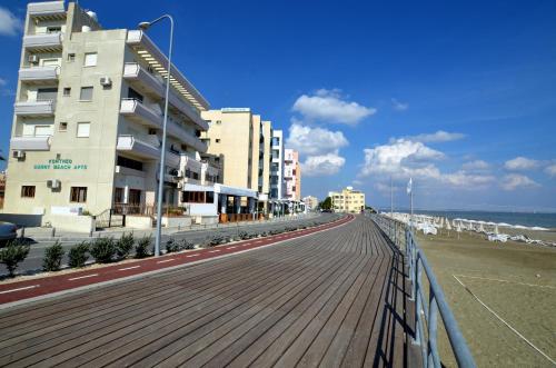 una passerella sulla spiaggia accanto a un edificio di Blu Studio on the Sea a Larnaka