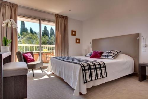 um quarto de hotel com uma cama e uma varanda em Hôtel Le Cottage em Argelès-sur-Mer