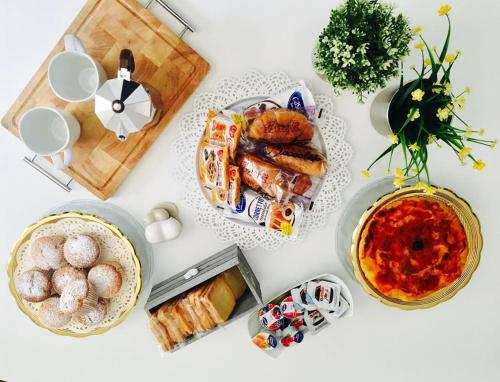 een tafel met borden met eten en gebak bij Oikos in Matera