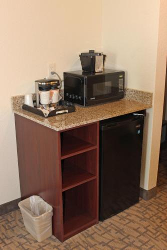 a kitchen counter with a microwave and a refrigerator at Cobblestone Inn & Suites - Lamoni in Lamoni