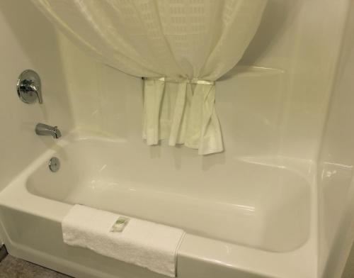 a white bath tub with a shower curtain at Cobblestone Inn & Suites - Lamoni in Lamoni