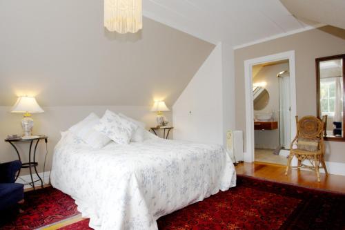 a bedroom with a white bed and a red rug at Cobden Garden in Napier