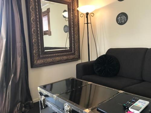 a living room with a couch and a mirror at Cambridge Coach House in Cambridge