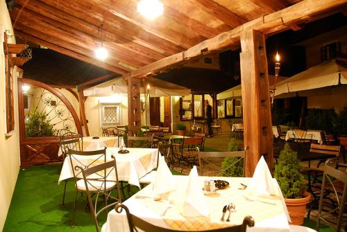 a restaurant with white tables and chairs and wooden ceilings at Guest House pri Vodniku in Ljubljana