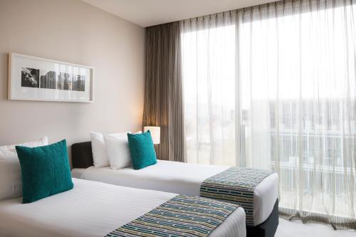um quarto de hotel com duas camas e uma janela em Quest Carlaw Park Serviced Apartments em Auckland